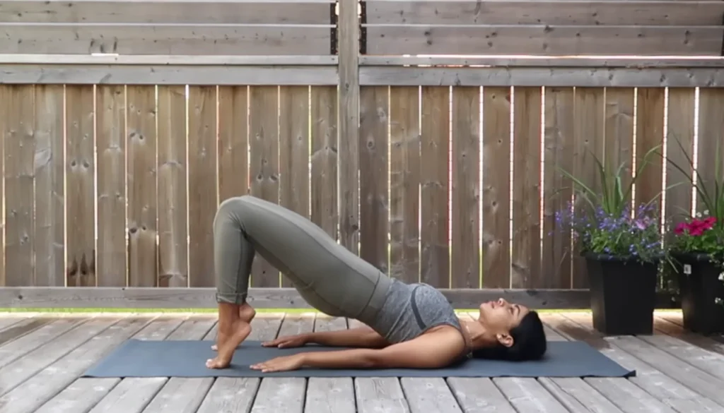 A lady performs a Bridge Pose for weight lose in somatic yoga