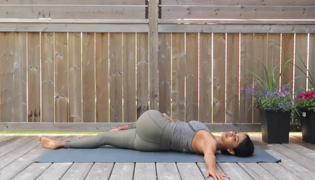 A lady performs a Supine Twist for weight lose in somatic yoga