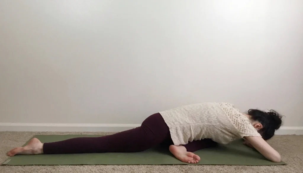 A lady performs a Pigeon Pose (Eka Pada Rajakapotasana – Forward Bend)