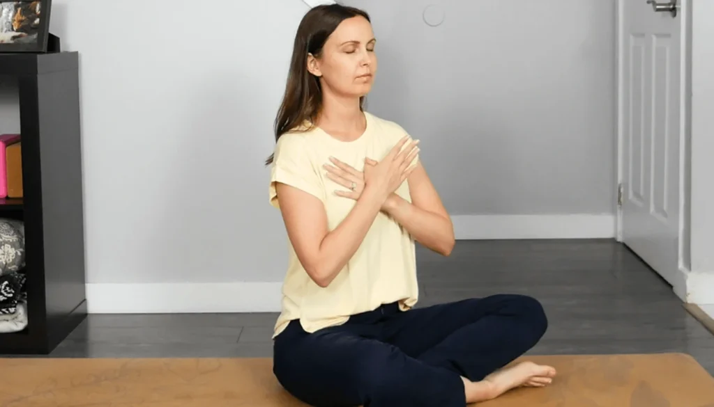 A lady sitting on the floor and performs a grounding exercise
