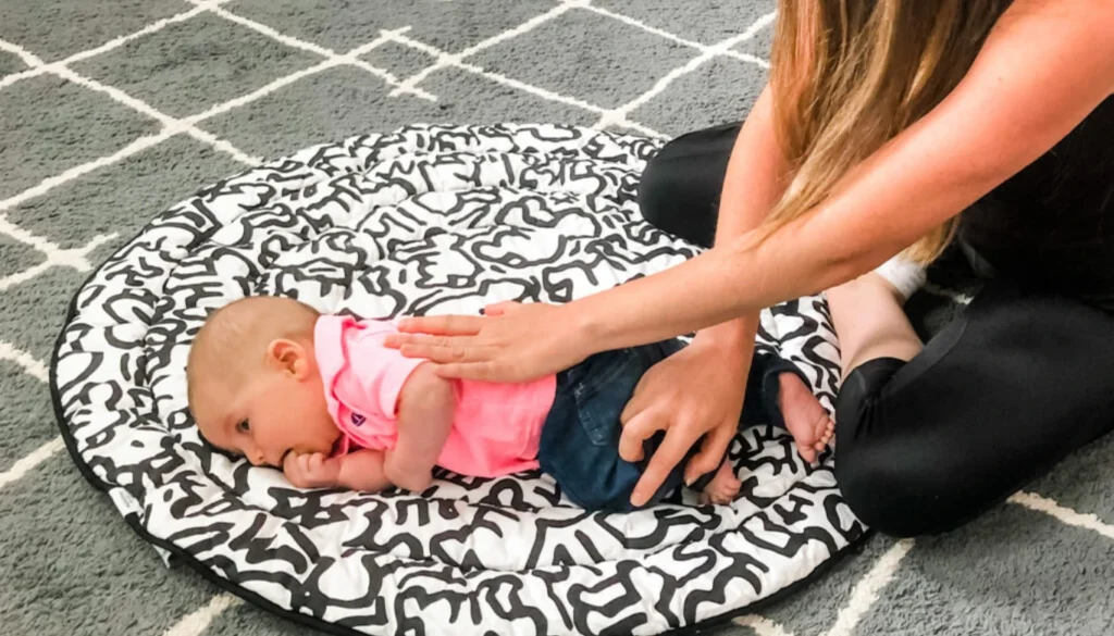 A mother performs a rolling baby pose