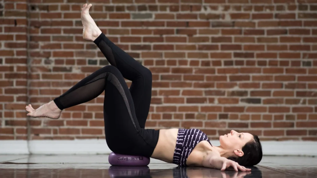 A lady laying on the floor and performs a somatic excercise
