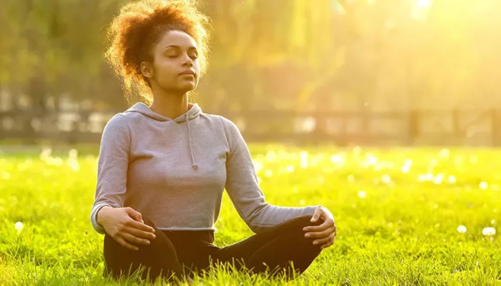 A lady sitting in the garden and performs a full body awareness
