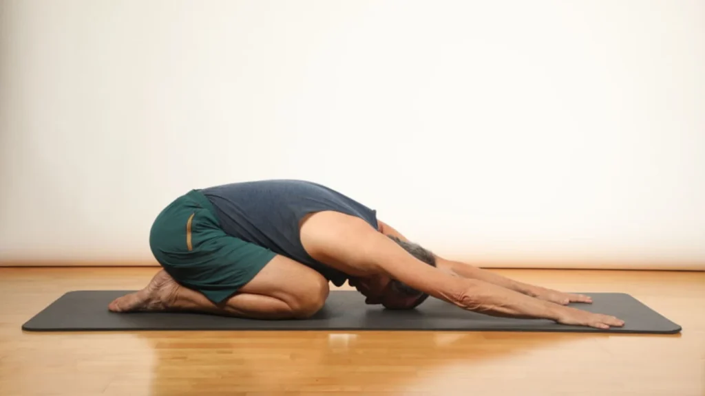 A man laying on the floor and performs a spine wave